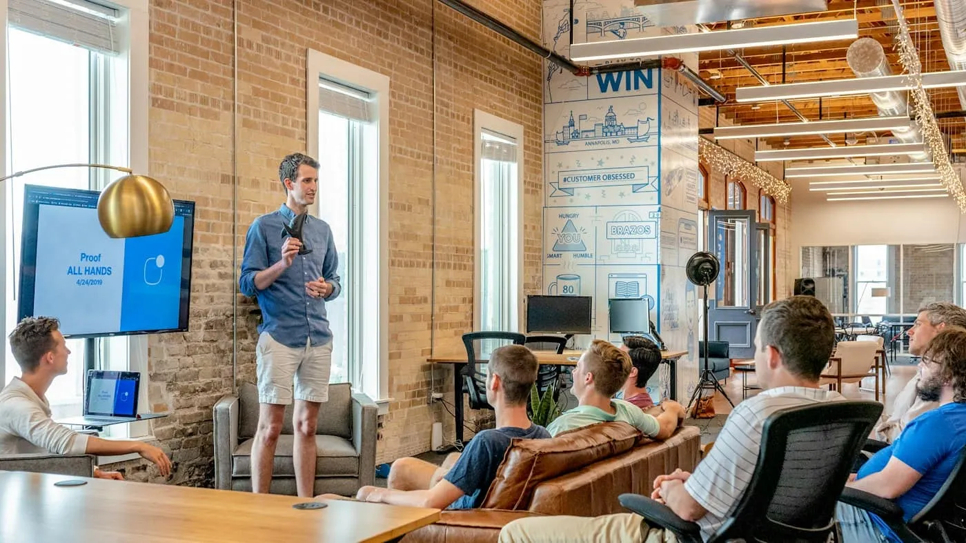 Founder presenting to a small team in a bright open-plan office