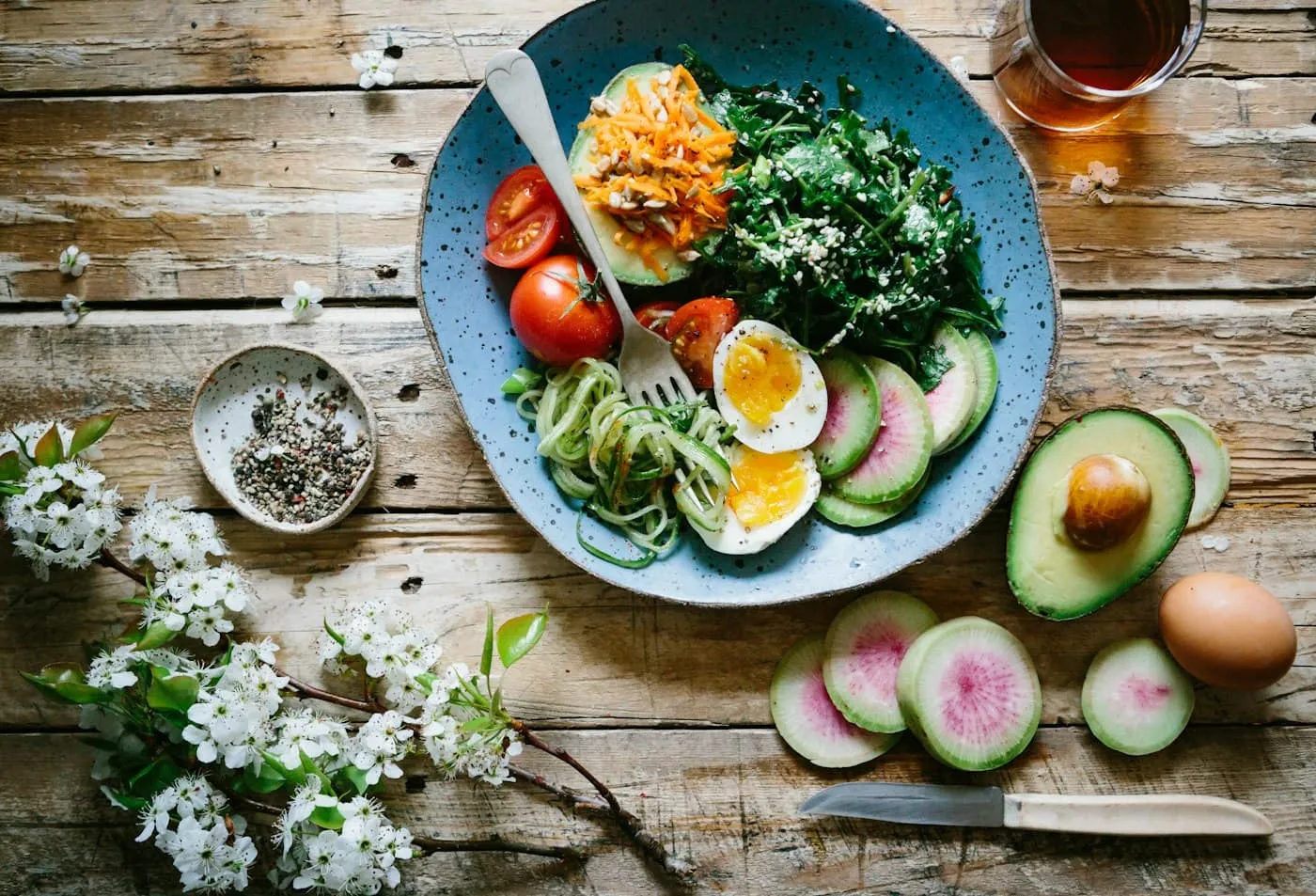 Colourful bowl of salad with eggs, avocado and vegetables on a wooden table