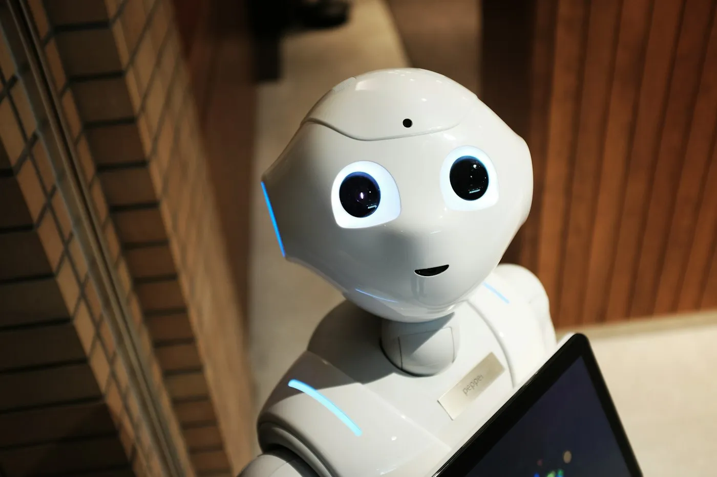 Friendly white humanoid robot holding a tablet, representing everyday AI assistants