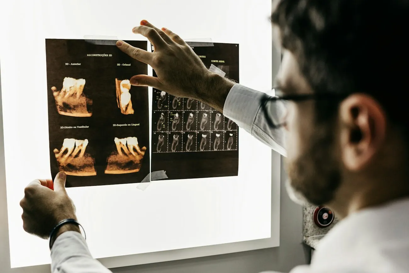 Dentist studying a set of dental radiographs on an illuminated viewing box